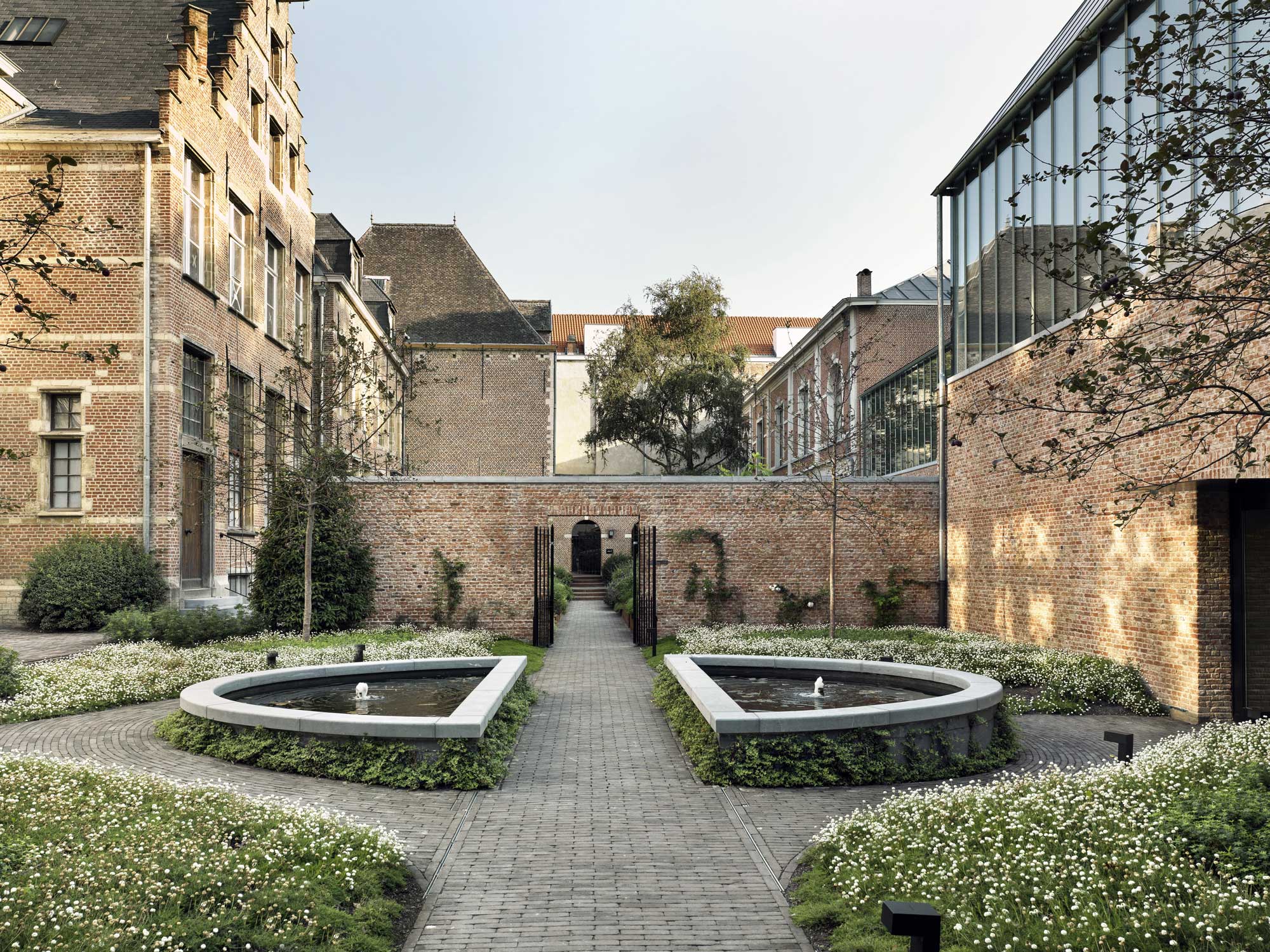 Historic courtyard with symmetrical fountains and lush greenery at Gharieni.