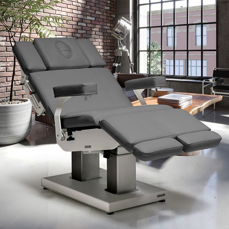 Luxurious Gharieni spa treatment table in modern, sunlit studio setting.