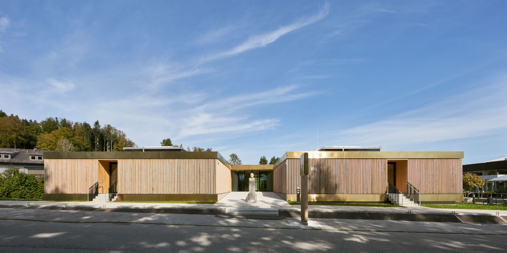 Modern spa facility with wooden exterior under clear sky at Gharieni.