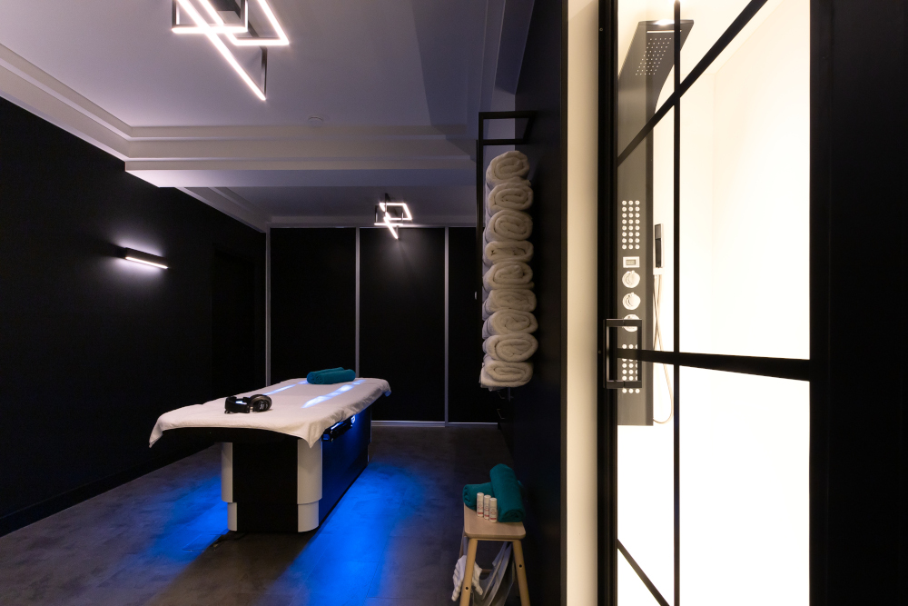 Luxurious spa room with Gharieni treatment table, ambient lighting, and neatly stacked towels.