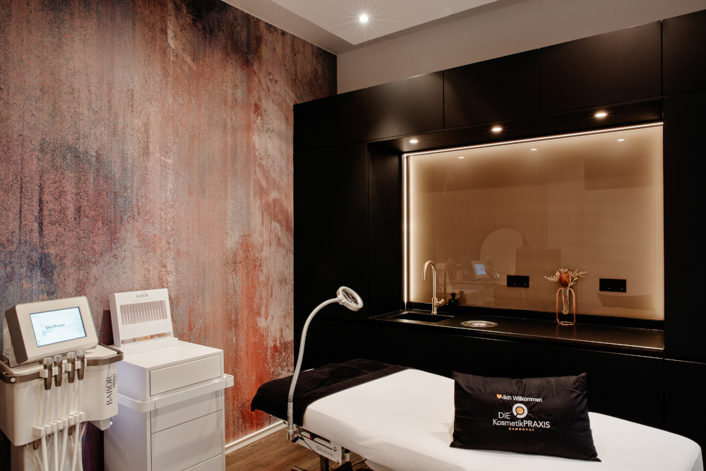 Luxurious spa room with treatment table, modern equipment, and elegant decor.