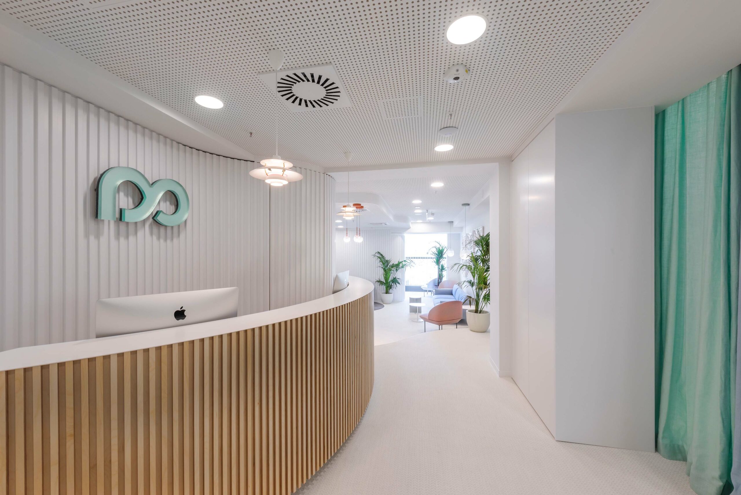 Modern spa reception with curved wooden desk, sleek design, and soft lighting.