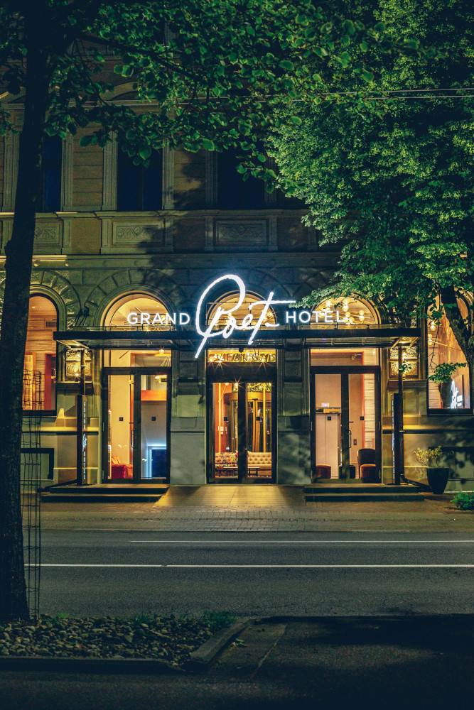 Luxurious hotel entrance at night with elegant lighting and grand architecture.