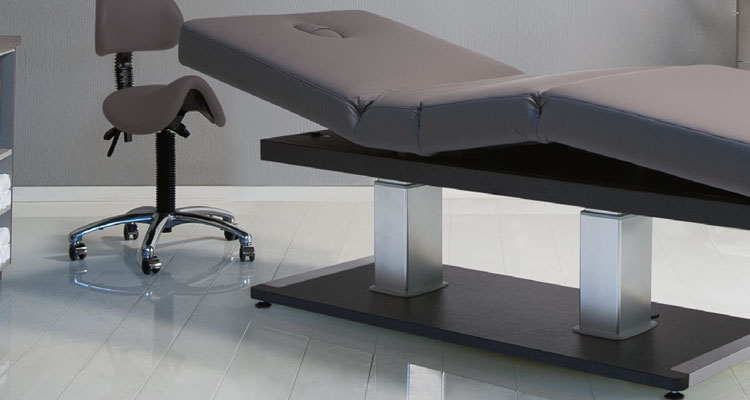 Luxurious Gharieni spa treatment table and ergonomic chair in modern setting.