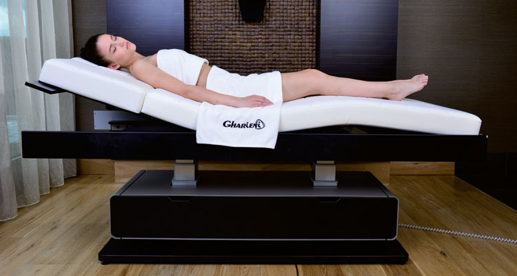 Gharieni premium spa table with client, modern luxury wellness equipment.