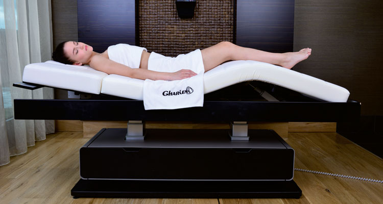 Gharieni luxury treatment table in spa setting with relaxing ambiance.