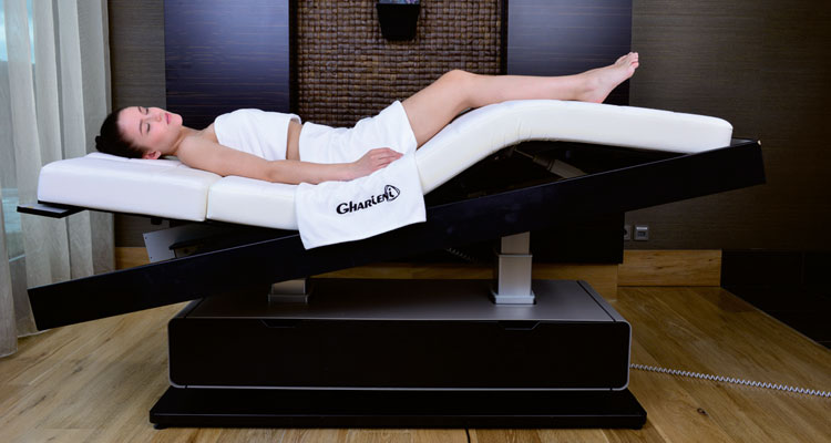 Gharieni premium spa treatment table with relaxed client in serene setting.