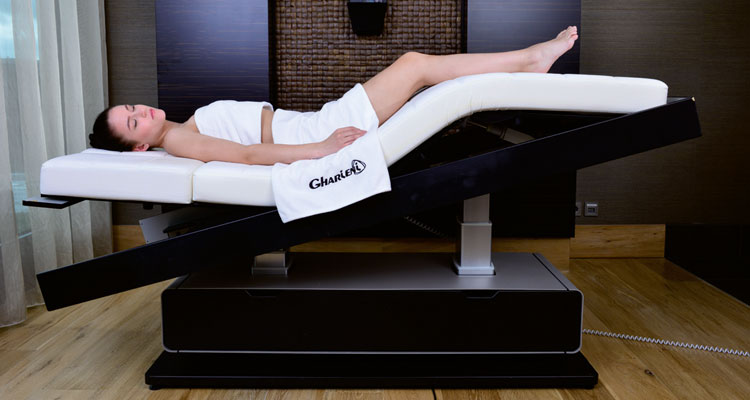 Gharieni premium spa table with client, ergonomic design, luxury wellness equipment.