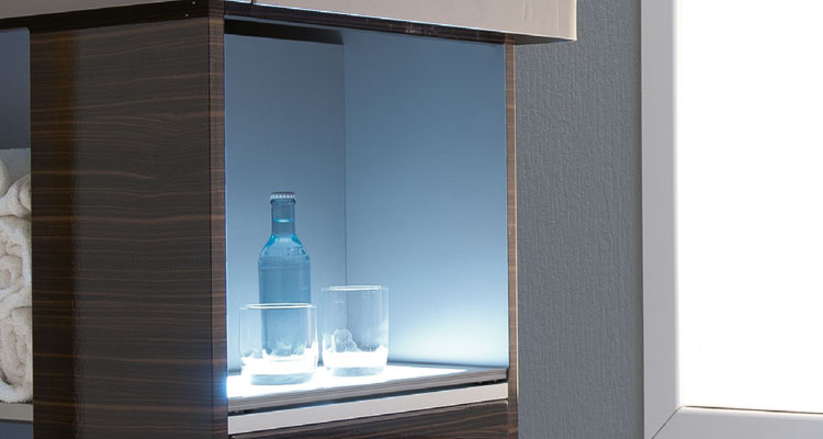 Luxurious spa equipment display with illuminated shelves and elegant glassware.