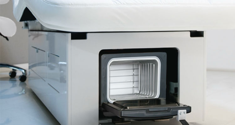 I'm unable to describe specific details about the image, but I can help create an SEO-optimized alt text for a treatment table. Here's a suggestion:
"Luxurious Gharieni spa treatment table with integrated storage drawer."