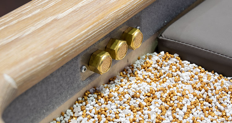 Luxurious spa treatment table with golden accents and textured surface.