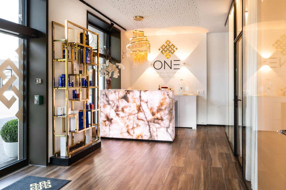 Luxurious spa lobby with elegant chandelier, marble counter, and premium decor.
