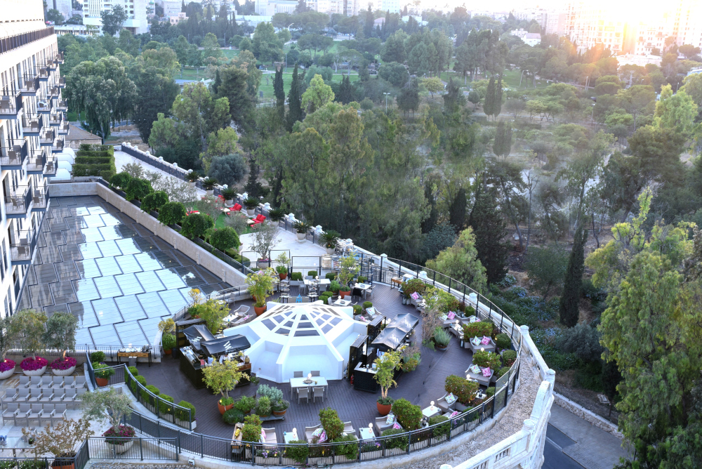 Luxury rooftop spa with premium treatment tables surrounded by lush greenery.