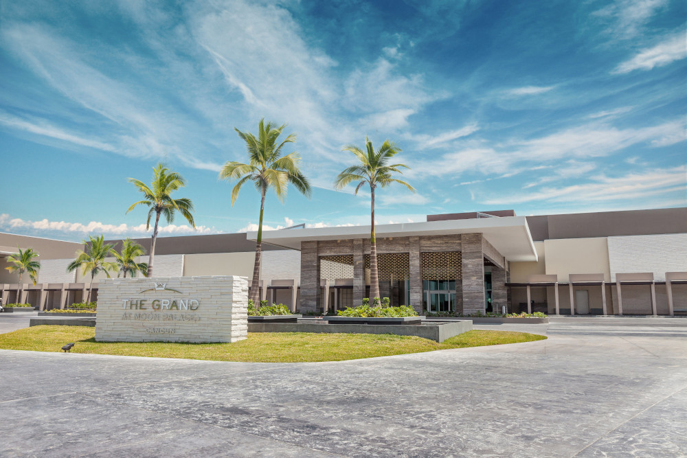 Modern luxury spa facility with palm trees and sleek architecture under a vibrant sky.