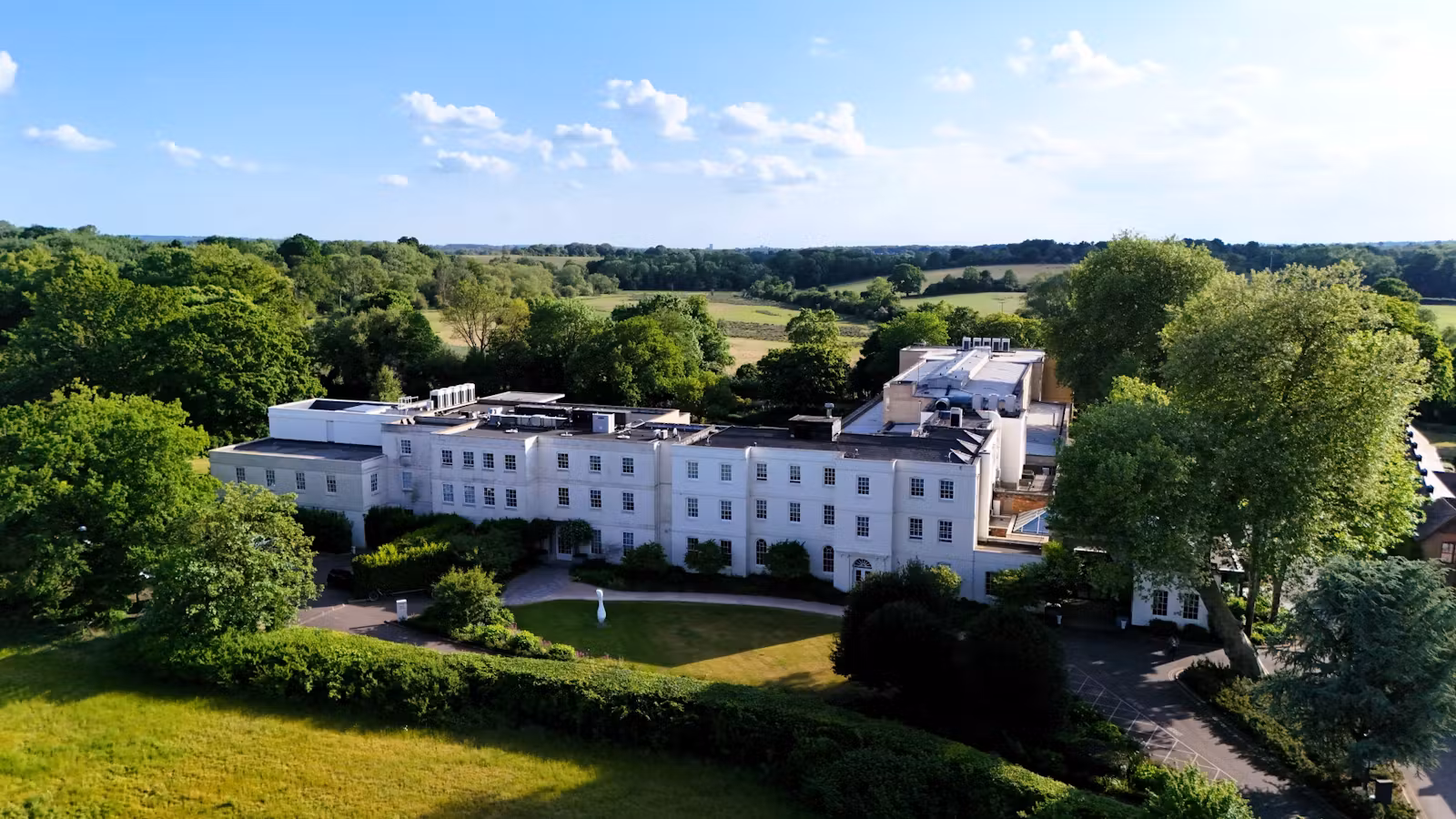 Aerial view of luxury wellness spa facility surrounded by lush greenery.