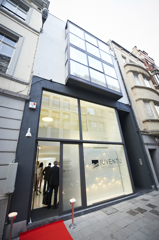Modern spa center facade with large glass windows and red carpet entrance.