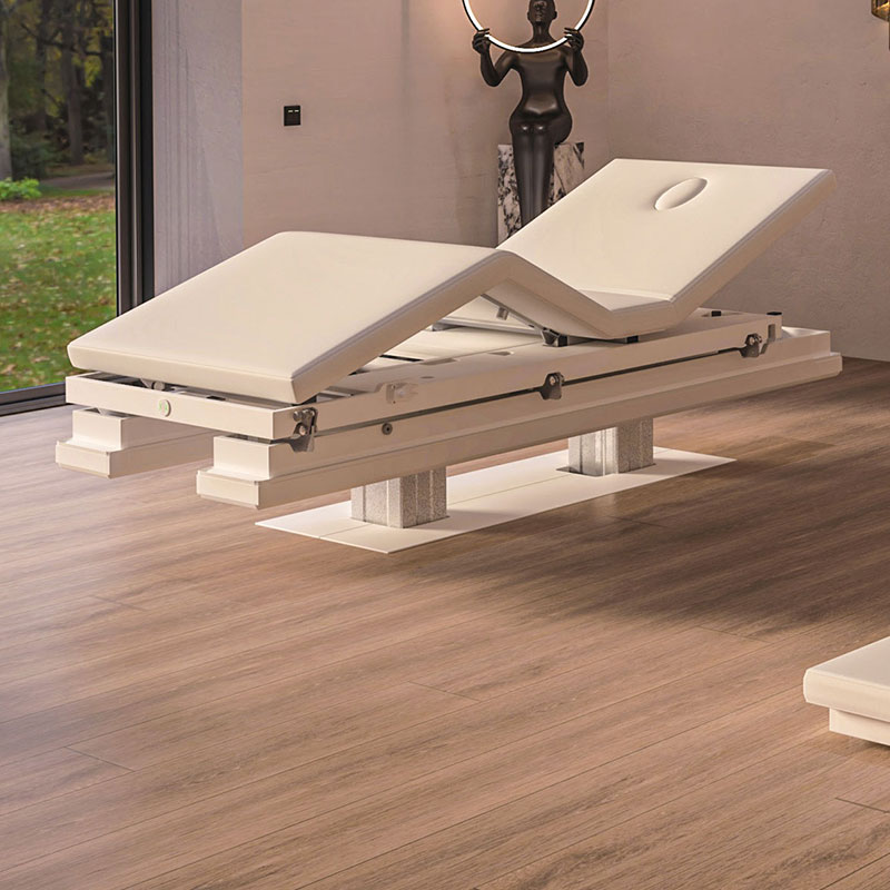 Luxurious Gharieni spa treatment table in serene, modern wellness setting.