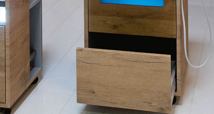 Open wooden spa equipment drawer on sleek Gharieni treatment table.