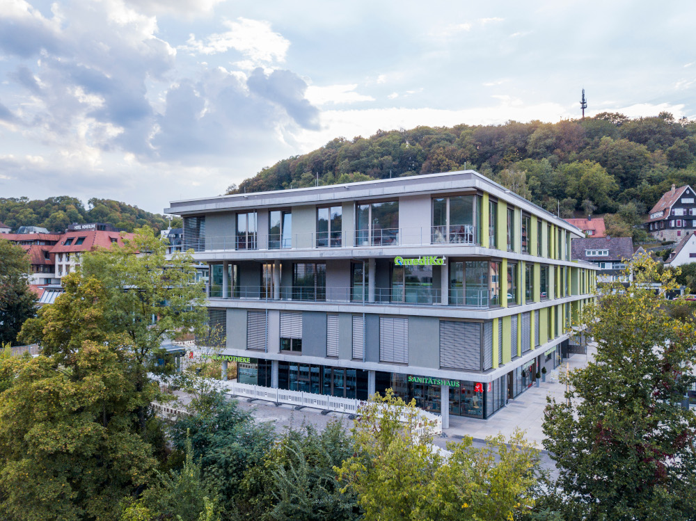 Modern Gharieni building amidst lush greenery and urban landscape.