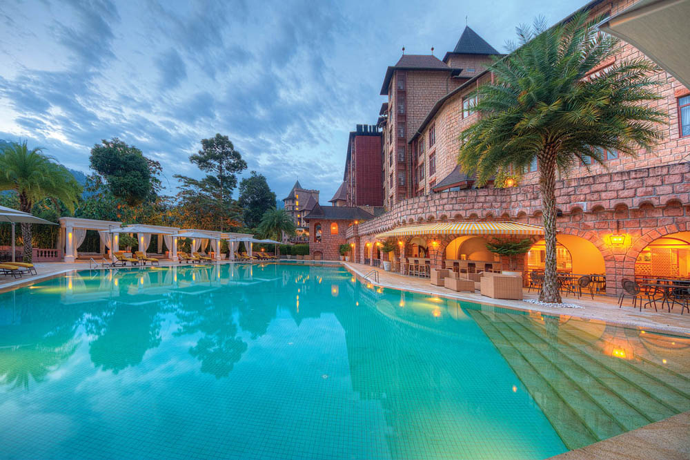 Luxurious spa resort poolside featuring elegant cabanas and lush greenery at sunset.