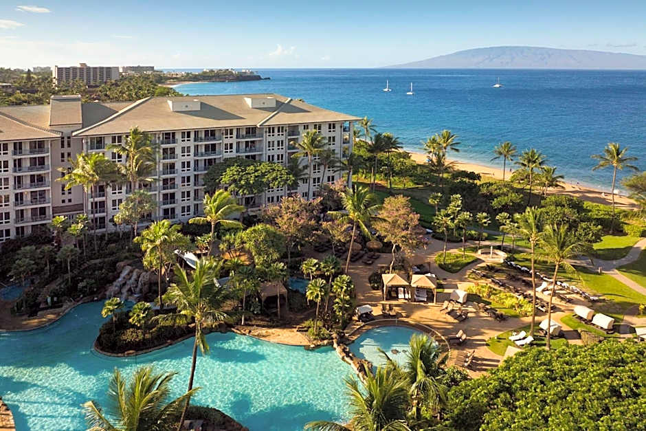 Luxurious beachfront resort with pools and palm trees, ideal for spa treatment tables.