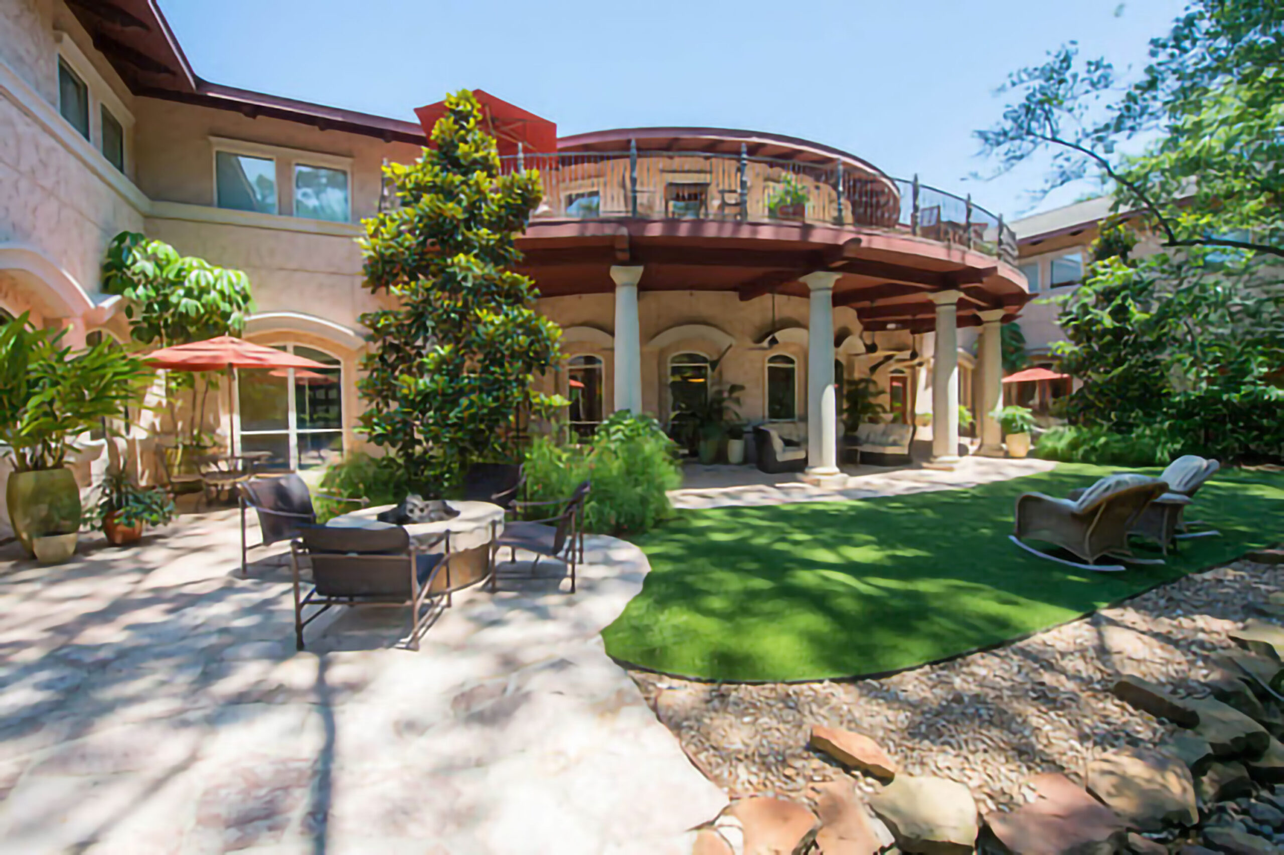 Luxurious garden with elegant patio furniture and lush greenery in a spa setting.