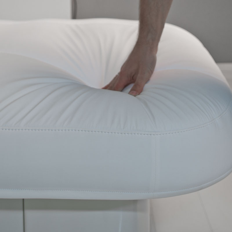 Hand pressing soft, luxurious spa treatment table from Gharieni. Premium comfort and design.