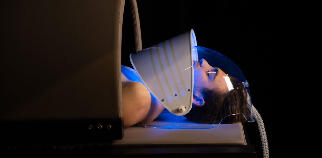 Gharieni premium spa treatment table with light therapy mask in use.