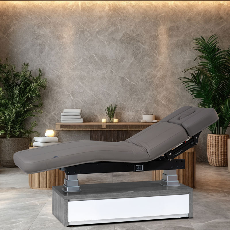 Luxury spa treatment table in elegant, serene setting with lush plants.